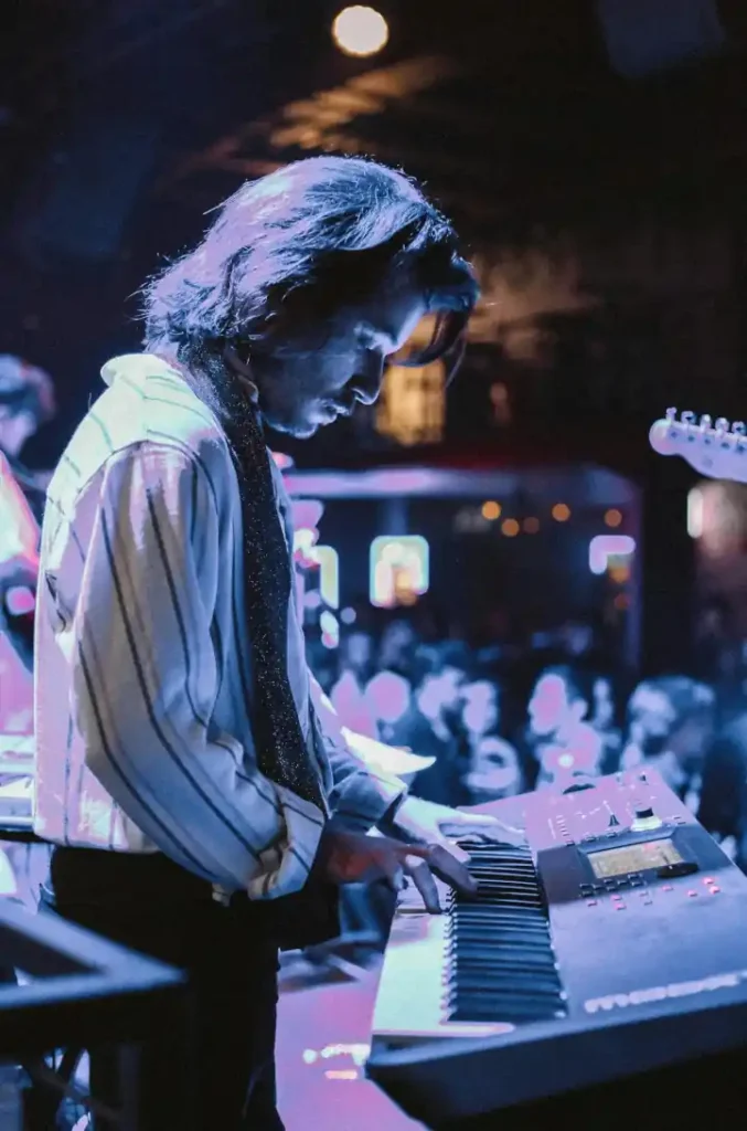 Klawiszowiec wykonuje utwór podczas swojego występu publicznego